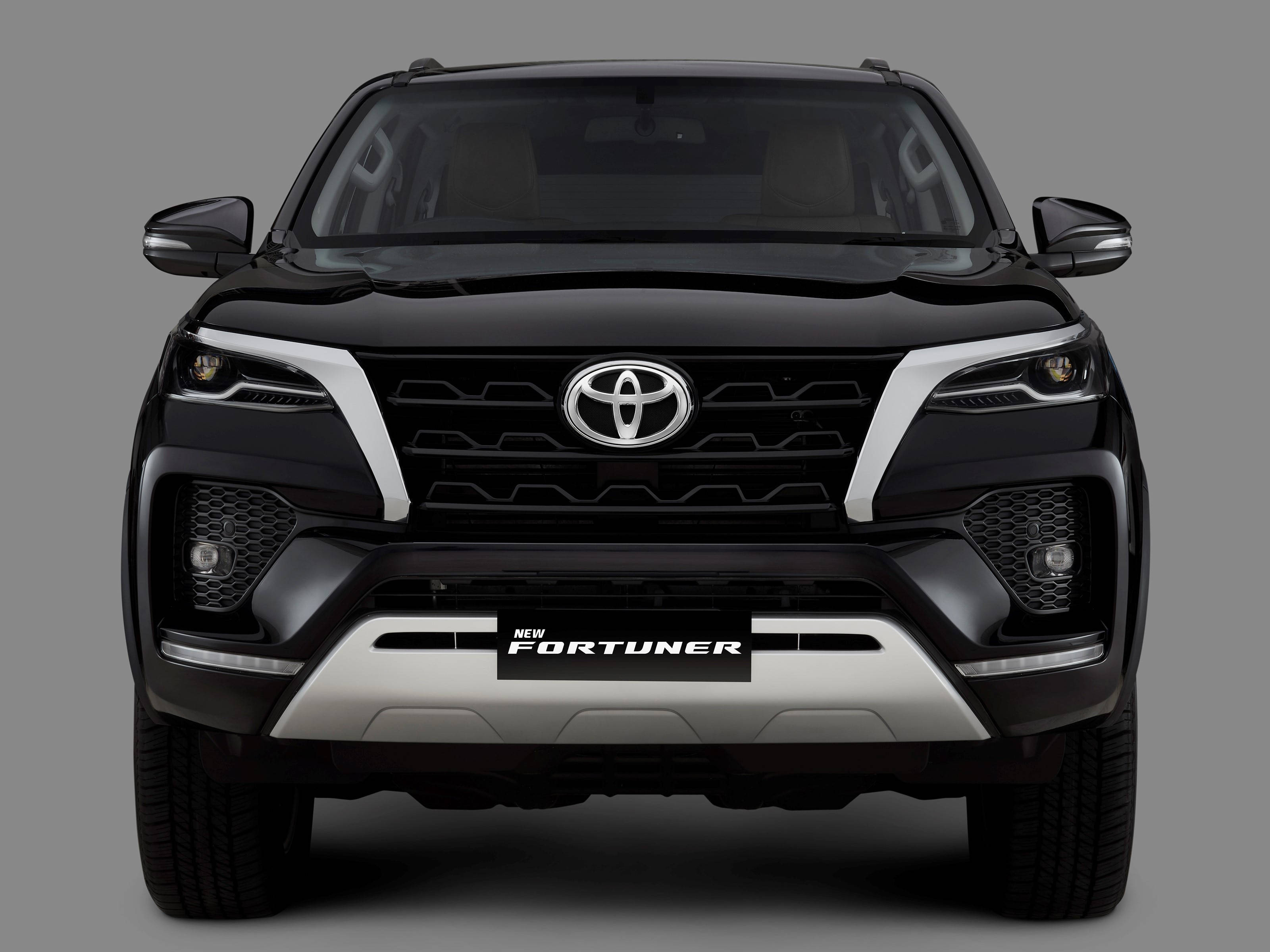 Toyota 桌布 壁紙 — 黑色豐田 Fortuner SUV 的正面視圖，帶有鍍鉻飾邊和醒目頭燈，背景為中性灰色。