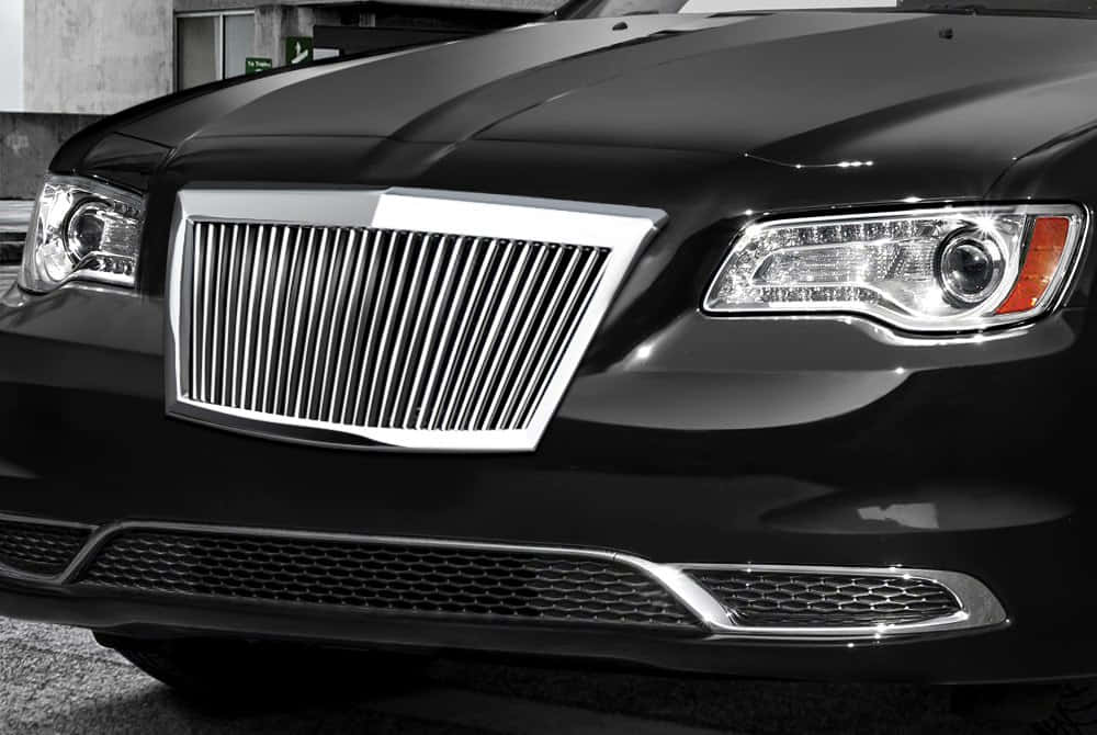 Car Grill 桌布 壁紙 — 黑色豪華轎車前格柵和車頭燈的特寫，反射環境光線。