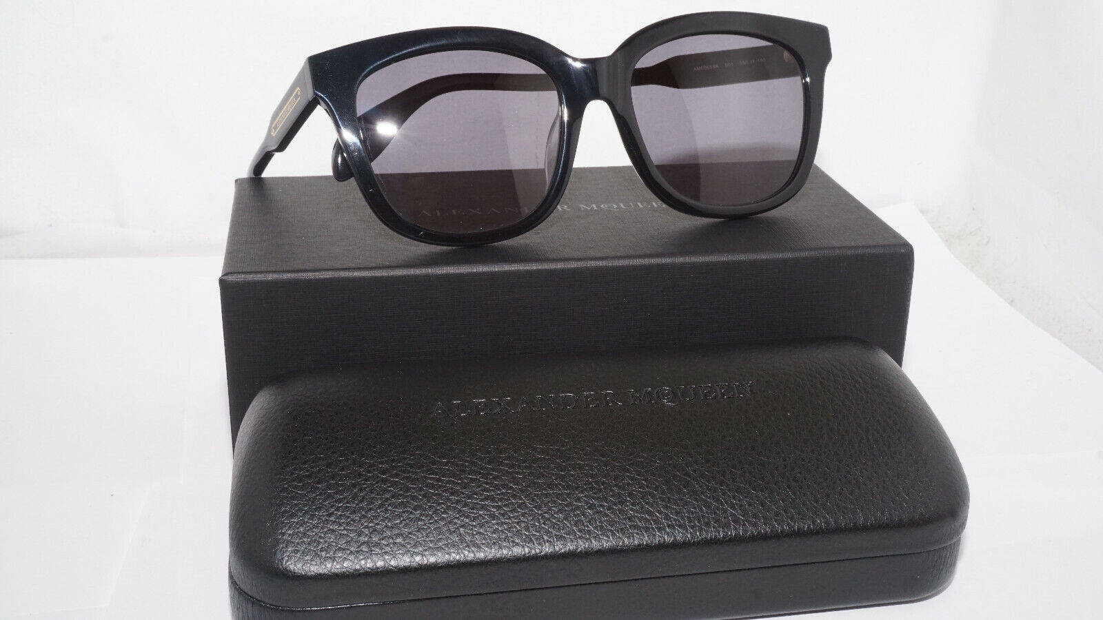 Sunglasses 桌布 壁紙 — 黑色貓眼太陽眼鏡放在其品牌盒子和眼鏡盒上，背景為純白色。