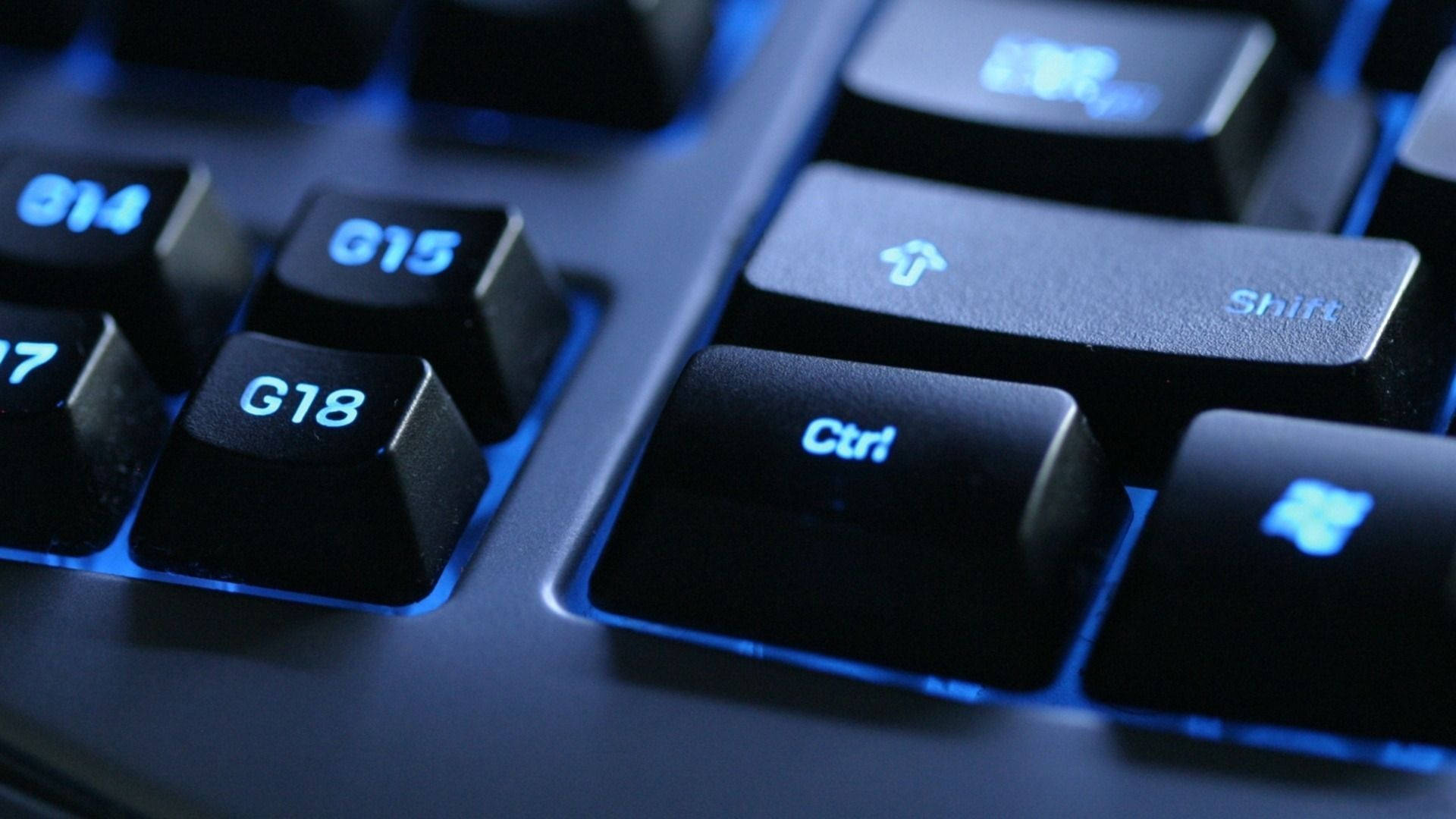 Information 桌布 壁紙 — 黑色鍵盤按鍵特寫，散發冷藍色背光，突出顯示 Ctrl、Shift 和 G18 G15 按鍵。