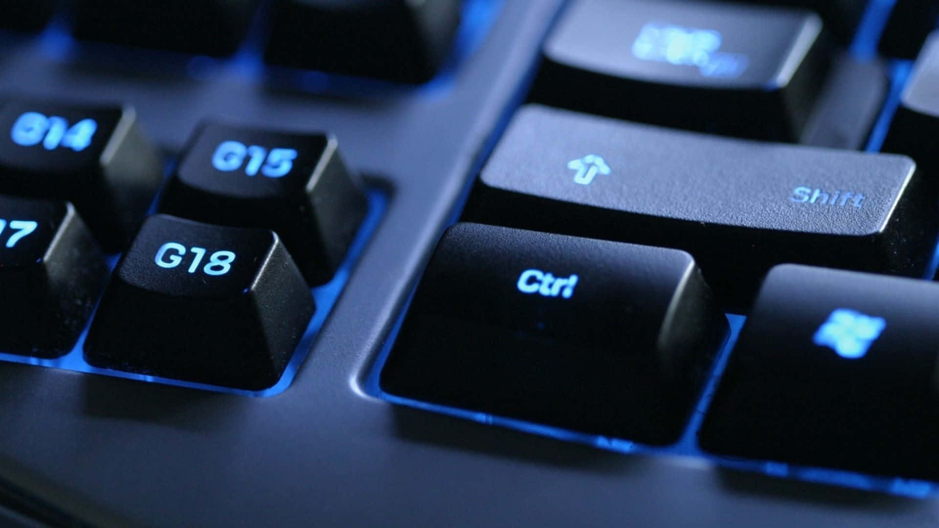 Gaming Keyboard 桌布 壁紙 — 黑色鍵盤特寫，藍色背光突出顯示 Ctrl、Shift 和 G18 等按鍵。