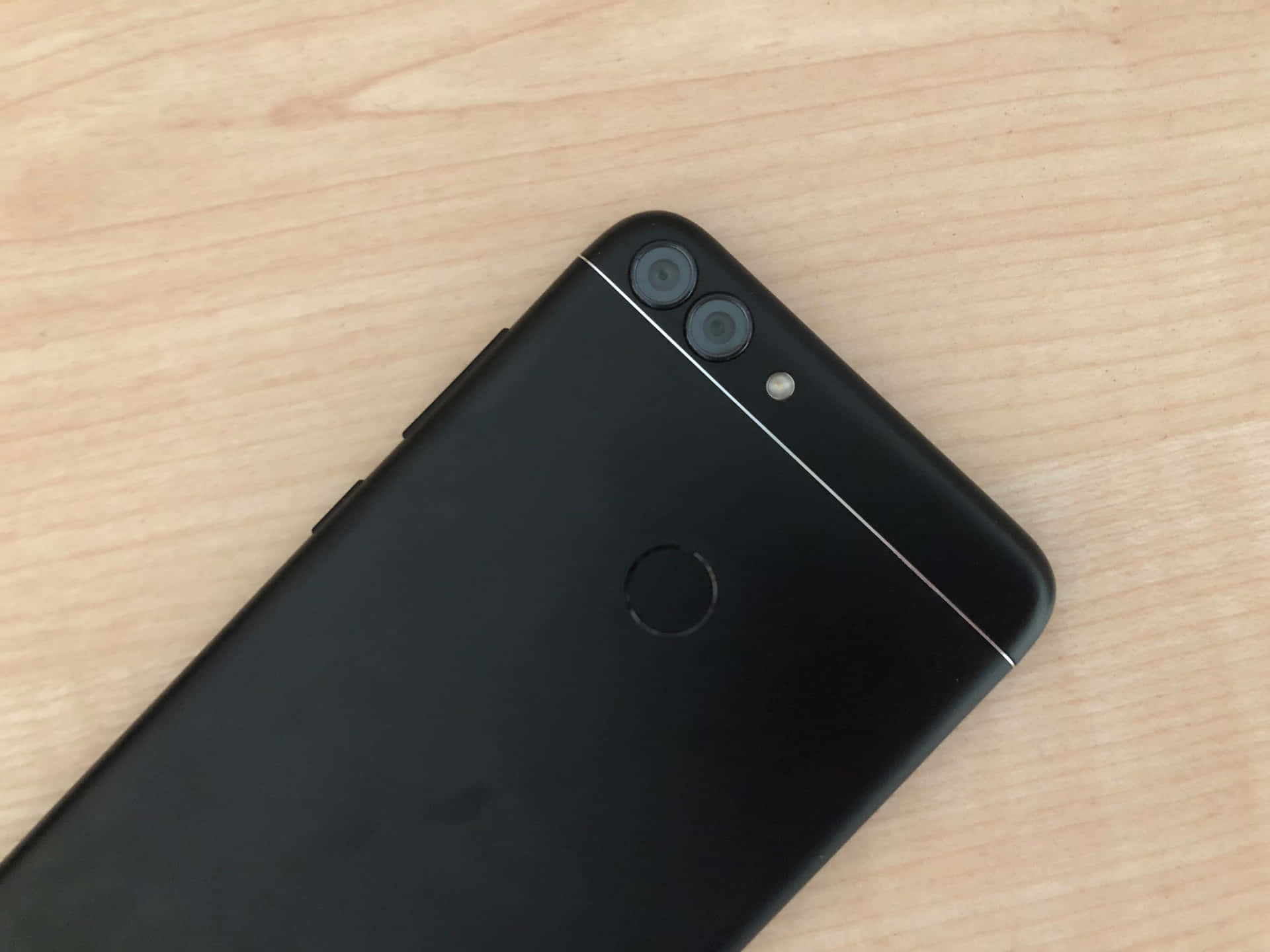 黑色雙鏡頭智慧型手機放在木桌上