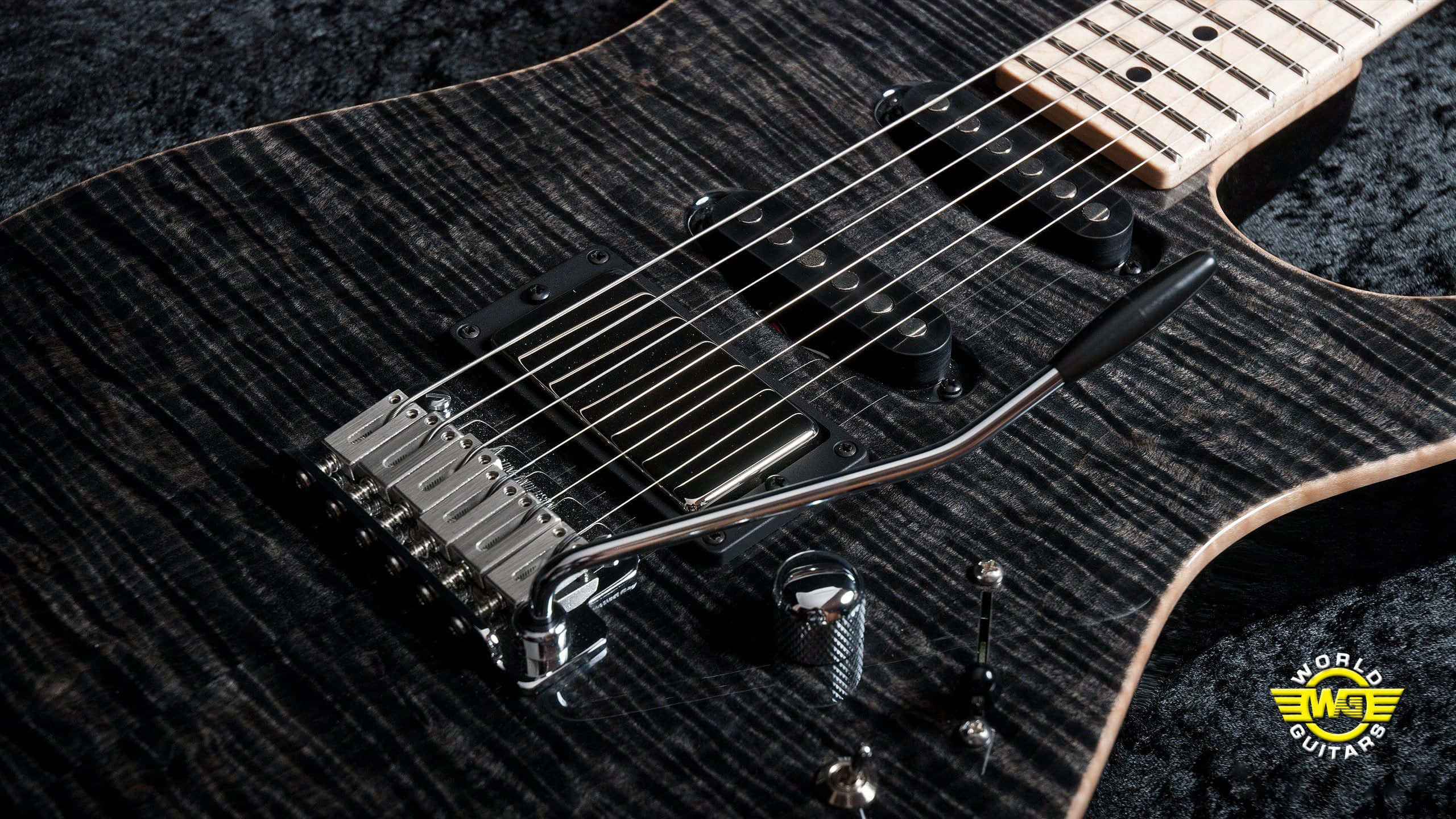 Guitar Amp 桌布 壁紙 — 黑色電吉他特寫，配備火焰楓木面板和鍍鉻硬件，置於深色紋理表面上。