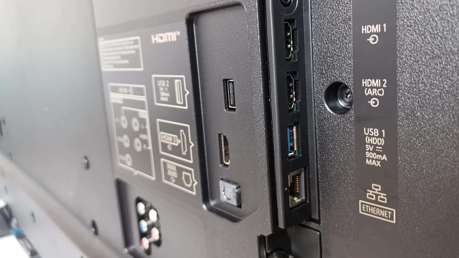 Hdmi 桌布 壁紙 — 黑色電視機背板的特寫，顯示HDMI、USB、乙太網路連接埠，標籤清晰，表面有紋理。