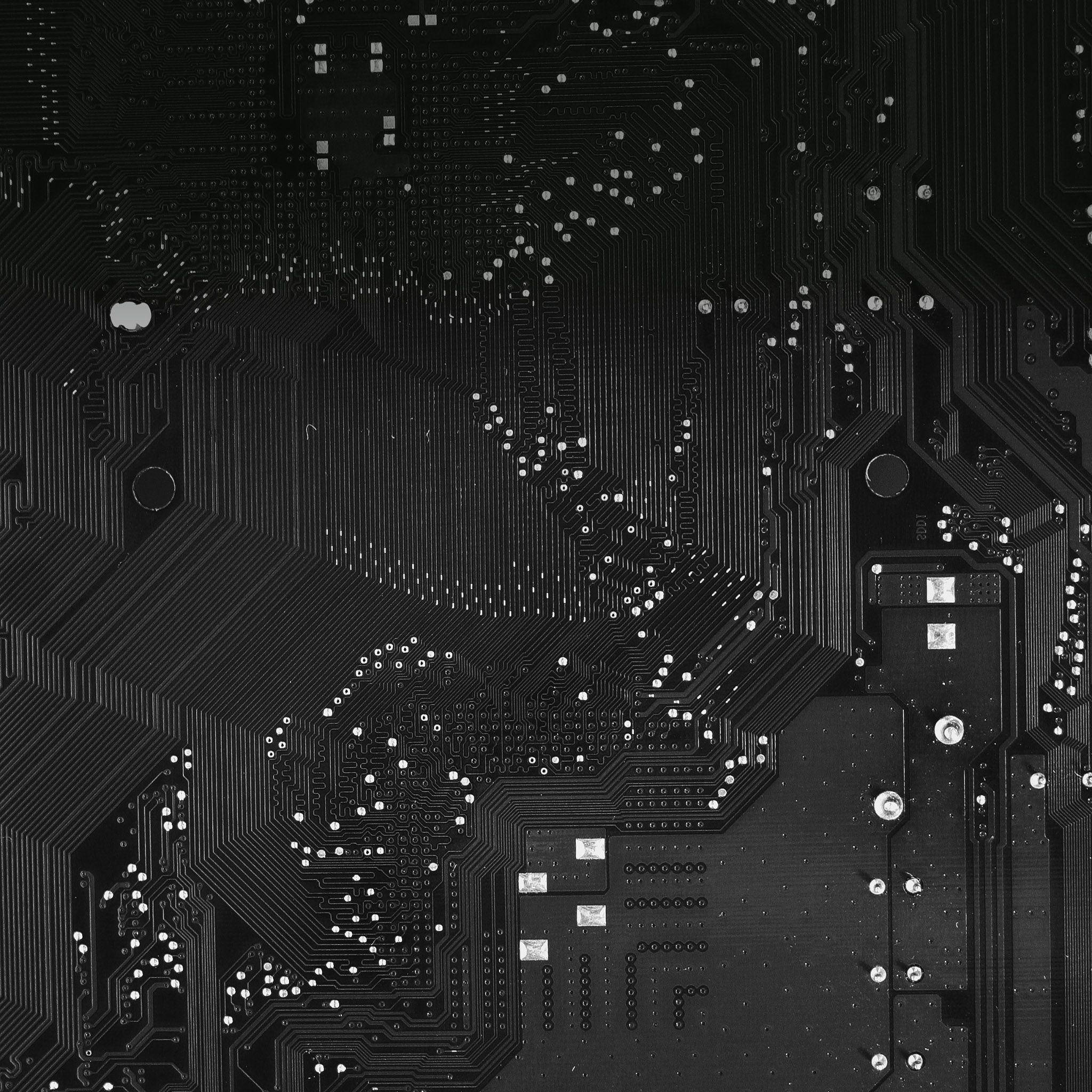 Motherboard 桌布 壁紙 — 黑色電路板的特寫，具有複雜的銀色路徑和焊點，在均勻照明下。
