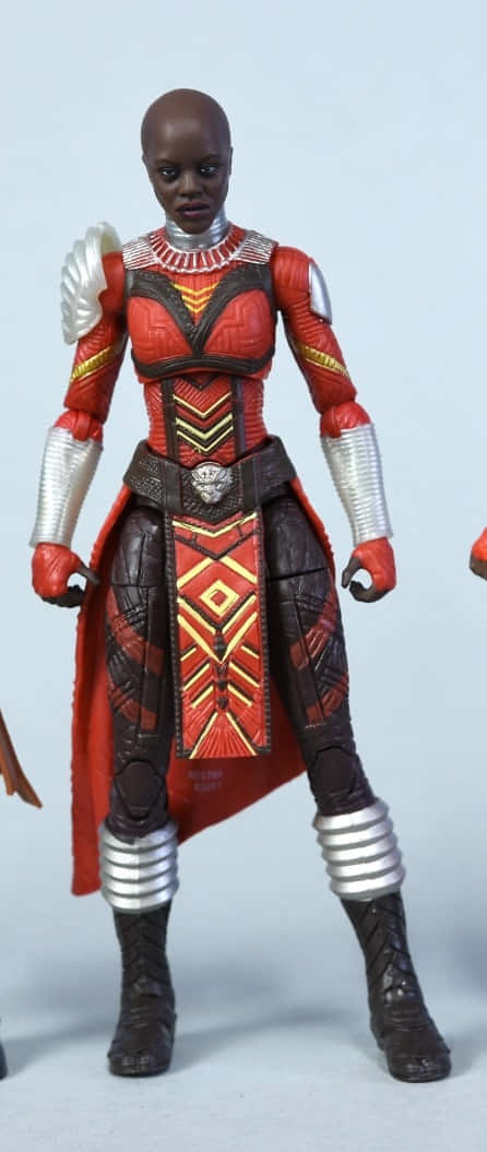 Dora Milaje 桌布 壁紙 — 黑豹中奧科耶的詳細動作人偶，身穿標誌性的紅色和銀色瓦坎達盔甲，站在純淺灰色背景前。