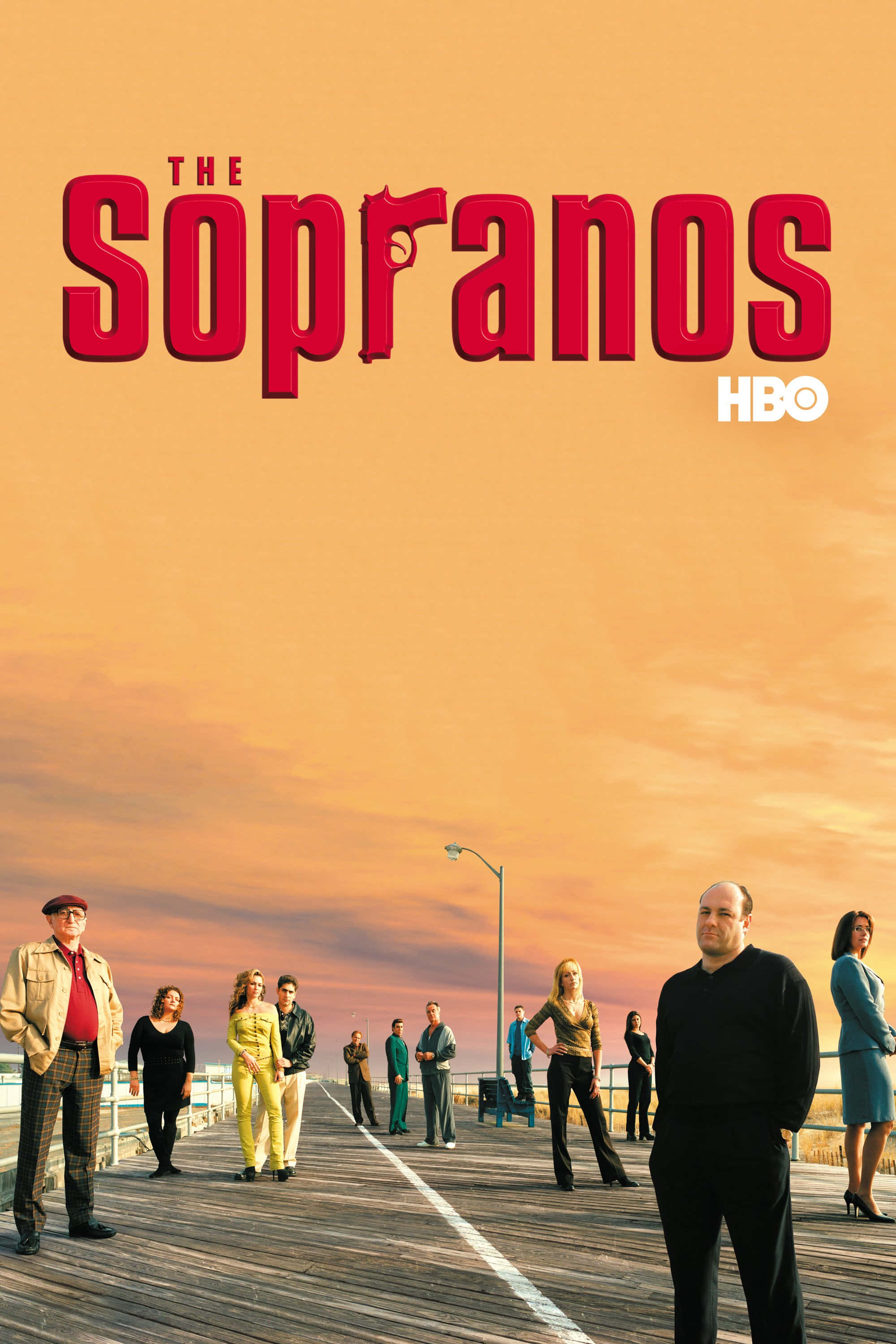 the sopranos 桌布 壁紙 — 《黑道家族》的演員們站在木製碼頭上，背景是溫暖的橙色日落天空，並有粗體紅色標題文字。