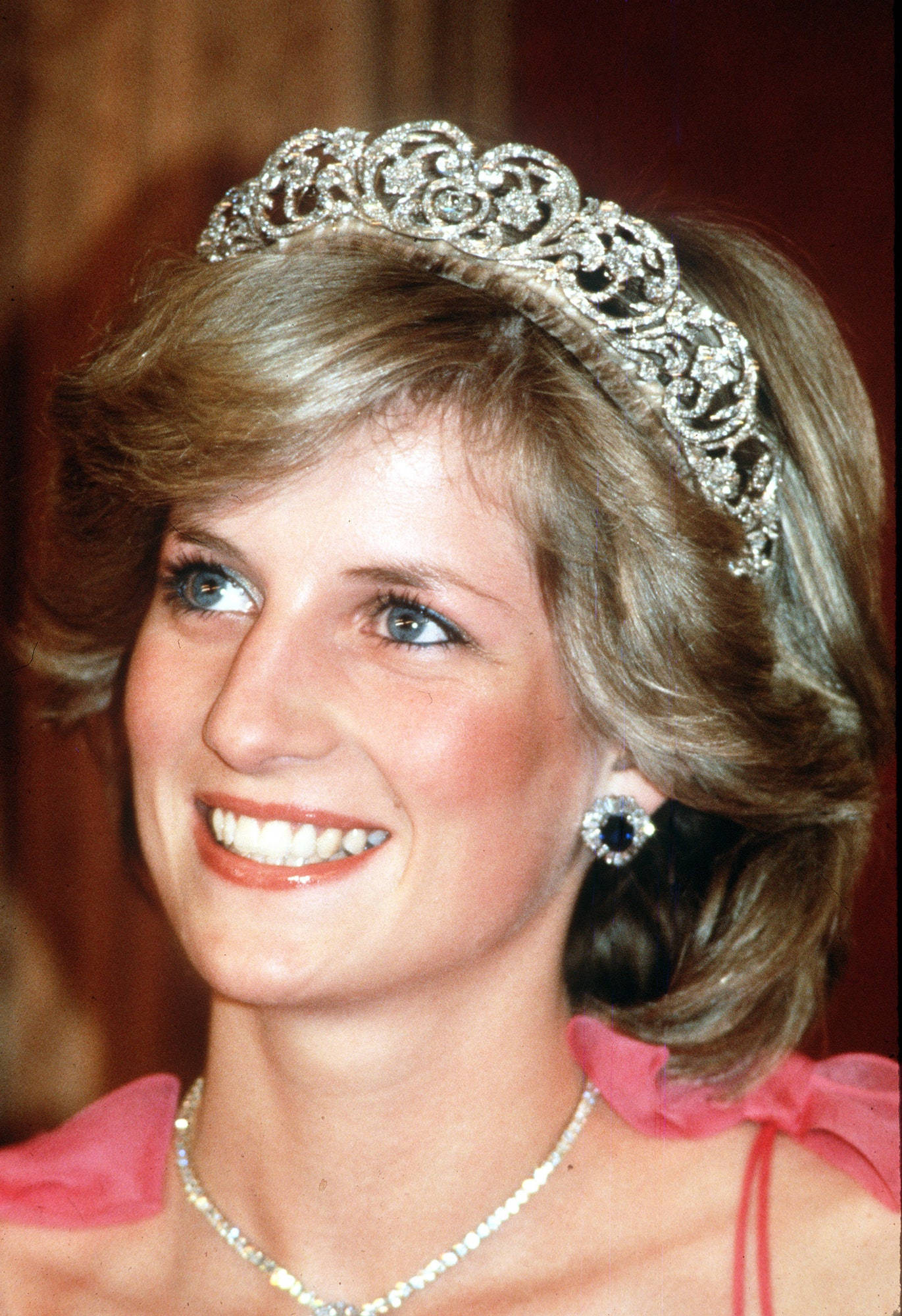 Princess 桌布 壁紙 — 黛安娜王妃溫暖微笑，佩戴閃爍鑽石头飾和相配耳環，身穿粉紅色連衣裙。