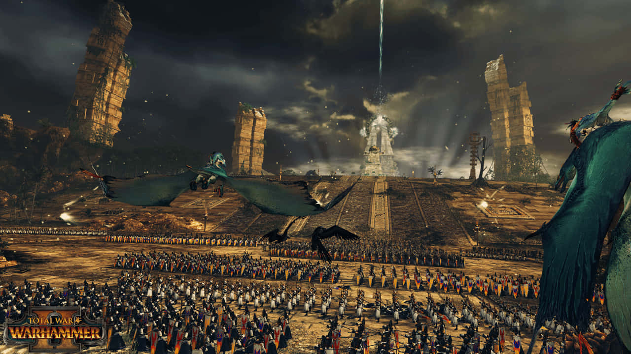 Total War Warhammer 2 桌布 壁紙 — 龐大的軍隊和巨大的飛行爬行動物在暴風雨的天空下聚集在一個巨大的廢墟前，形成一個奇幻的戰鬥場景。
