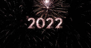 閃爍的2022文字，背後有煙花在夜空中爆炸。 — 新年快樂 2020 壁紙