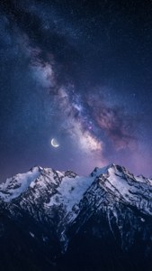 雪覆的山峰在星滿的夜空下，新月和銀河系