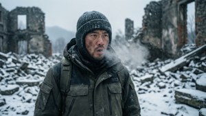 一個穿著冬季裝備的男人站在被雪覆蓋的廢墟中呼出蒸汽。