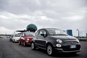 三輛Fiat 500汽車停放在陰天下的屋頂上。 — 飛雅特 壁紙