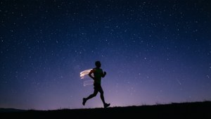 一個人在星空下夜跑，身後有光跡。