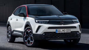 白色和黑色歐寶 Mokka X SUV，帶有紅色飾邊，停在瀝青上。 — 歐寶 壁紙