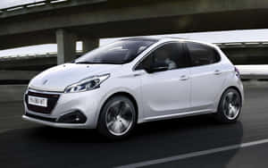 白色Peugeot 208在天橋下行駛，帶有動態模糊效果。 — Steam Deck 壁紙