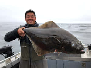 漁夫在灰色海洋的船上拿著大比目魚 — 船 壁紙