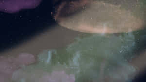 一隻發光的水母漂浮在充滿星光的宇宙環境中，周圍有色彩繽紛的星雲。 — 宇宙 壁紙