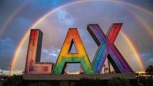 霓虹LAX標誌在暮色中的雙彩虹下發光。