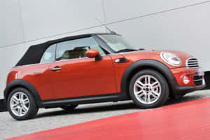 紅色MINI Cooper敞篷車停在紅色地毯上，灰色牆壁。 — 酷車 壁紙