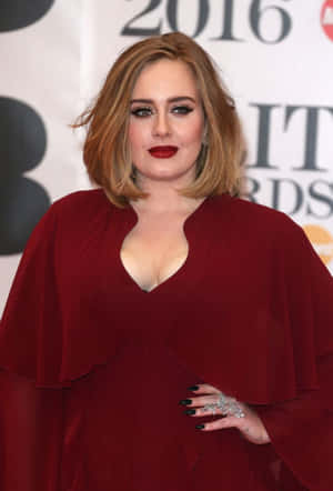 Adele 在2016年全英音樂獎上穿著紅色連衣裙，搭配大膽的紅唇和黑色指甲。 — 愛黛兒 壁紙