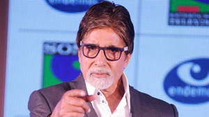 Amitabh Bachchan 在活動中戴著眼鏡和西裝指向前方。 — 阿米塔布·巴强 壁紙