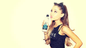 Ariana Grande 手持水瓶，嘟起嘴唇，戴著貓耳髮箍。 — 亞莉安娜·格蘭德 GIF 壁紙