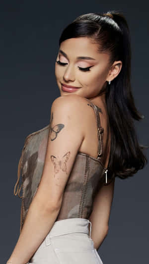 Ariana Grande 在工作室肖像中手臂上有蝴蝶刺青。