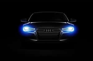 Audi 汽車在黑暗的攝影棚環境中帶有明亮的藍色車頭燈。 — Surface Pro 壁紙
