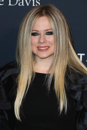 Avril Lavigne 在活動中穿著黑色服裝，金色頭髮，大膽妝容。 — 艾薇兒·拉維尼 壁紙