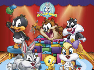Baby Looney Tunes 角色在有氣球的舞台上玩玩具。 — 樂一通 壁紙