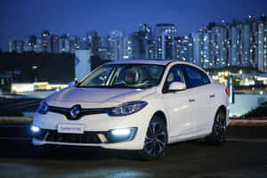 白色雷諾Fluence GT Line轎車夜間停泊，背後有城市燈光。 — 雷諾 壁紙