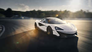 白色McLaren賽車在黃金時段於賽道上飛馳。 — 5120x2880 壁紙