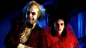 Beetlejuice 和他的新娘在藍色燈光下穿著哥德式服裝。 — 陰間大法師 壁紙