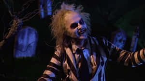 Beetlejuice 穿著條紋西裝在黑暗墓地中微笑 — 陰間大法師 壁紙
