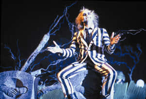 Beetlejuice 穿著條紋西裝坐在墓碑上，帶有閃電效果。 — 陰間大法師 壁紙