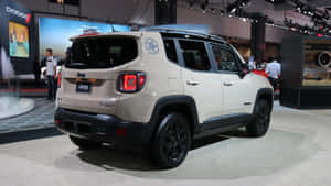 米色Jeep Renegade SUV在車展上展示，配有黑色車輪和星星貼紙。 — 吉普 壁紙