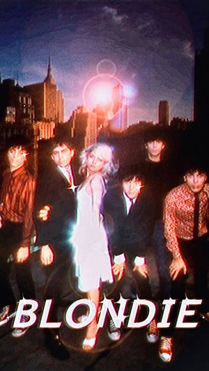 Blondie 樂隊成員在夜間霓虹燈照亮城市景觀前擺姿勢。 — 復古90年代風格 壁紙