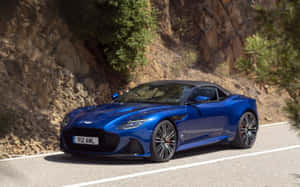 藍色 Aston Martin V12 Vantage 敞篷跑車在山路上行駛。 — Steam Deck OLED 壁紙