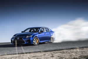 藍色Lexus轎車在沙漠道路上甩尾，帶有煙霧 — Surface Pro 壁紙