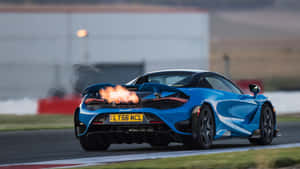 藍色McLaren跑車在賽道上加速，排氣管噴出火焰。 — 酷炫F1 壁紙
