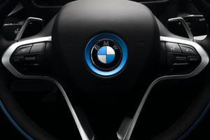 BMW i8 方向盤，帶有藍色發光標誌和控制按鈕。 — Vans 標誌 壁紙