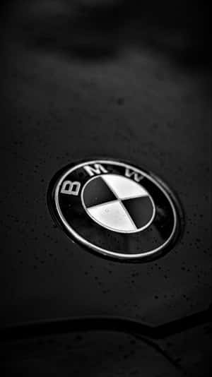 雨滴下的濕引擎蓋上的 BMW 標誌 — 中性 壁紙