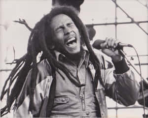 Bob Marley 閉上眼睛，熱情地唱入麥克風。 — 巴布·馬利語錄 壁紙