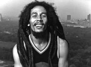 Bob Marley 微笑著，長髮綹，以城市和公園為背景。 — 巴布·馬利語錄 壁紙