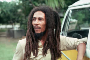 Bob Marley 靠在貨車上，背景有綠樹 — 巴布·馬利語錄 壁紙