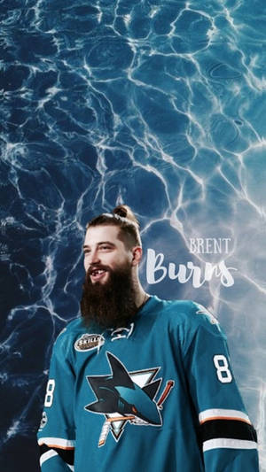 冰球運動員 Brent Burns 身穿鯊魚隊球衣，在水波紋背景中微笑。 — 運動 壁紙