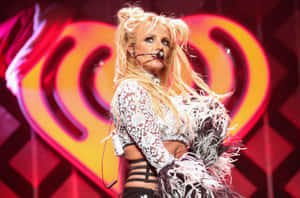 Britney Spears 在舞台上表演，身穿白色蕾絲服裝，帶有羽毛袖。 — 小甜甜布蘭妮 壁紙
