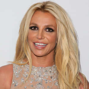 Britney Spears 穿著閃亮上衣，長長的金色頭髮，微笑著。 — 小甜甜布蘭妮 壁紙