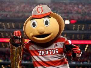 Brutus Buckeye 吉祥物在擠滿人的體育館中手持獎盃。 — 大學美式足球 壁紙